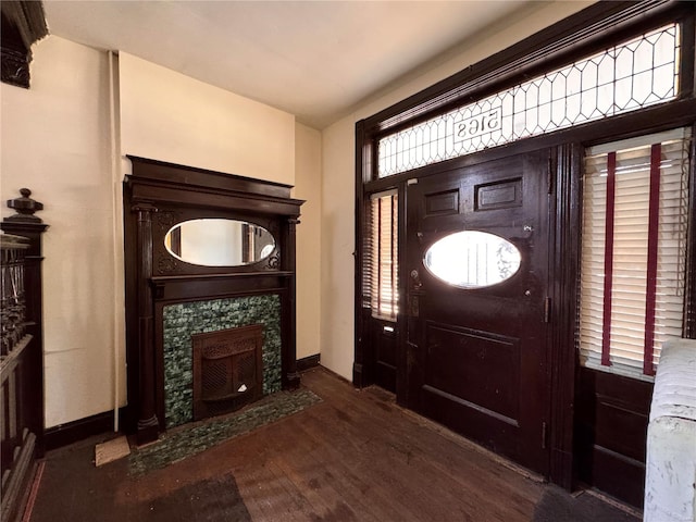 entryway featuring dark hardwood / wood-style flooring and a tile fireplace