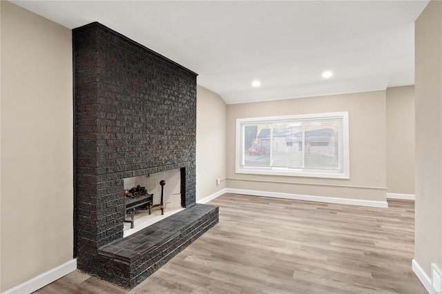 living room featuring light wood-type flooring and a fireplace