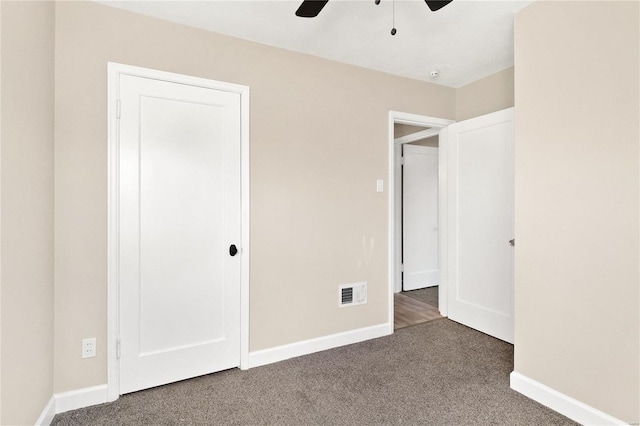 unfurnished bedroom with ceiling fan and dark carpet