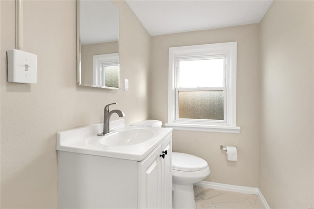 bathroom featuring toilet, vanity, and a healthy amount of sunlight