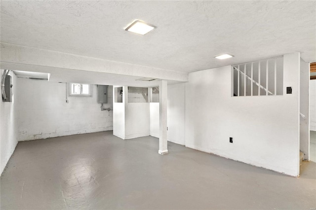 basement with electric panel and a textured ceiling