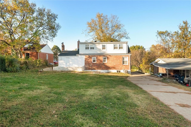 back of house featuring a lawn and a carport