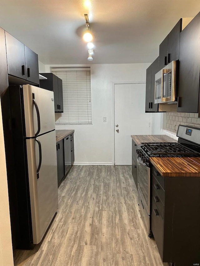 kitchen featuring light hardwood / wood-style floors, stainless steel appliances, and backsplash