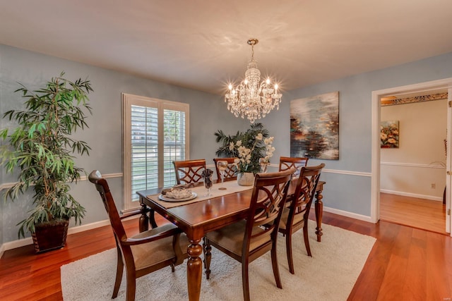 dining room featuring hardwood / wood-style flooring and an inviting chandelier