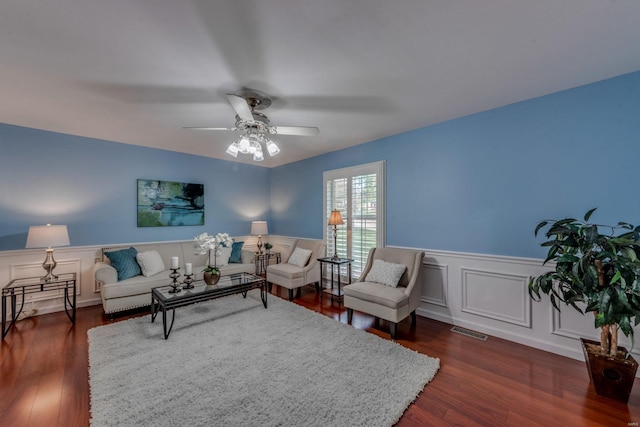 living room featuring dark wood-type flooring and ceiling fan