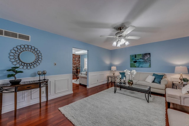 living room featuring ceiling fan and dark hardwood / wood-style floors