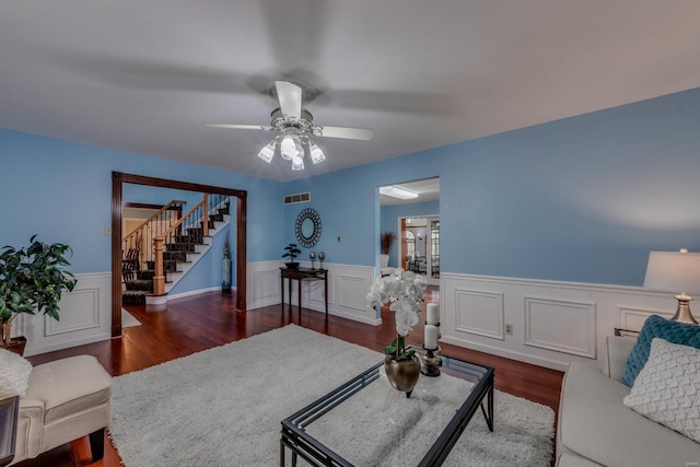 living room featuring dark hardwood / wood-style flooring and ceiling fan