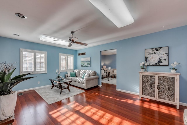 living room featuring dark hardwood / wood-style floors and ceiling fan