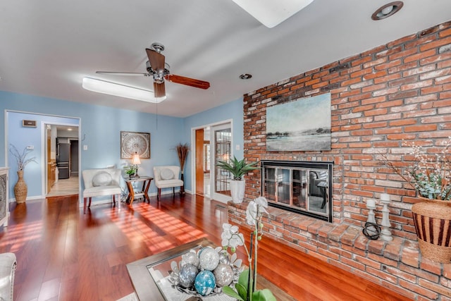 living room with a fireplace, hardwood / wood-style flooring, and ceiling fan