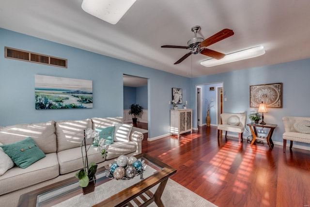 living room featuring ceiling fan and dark hardwood / wood-style floors