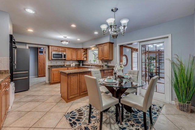 dining room with light tile patterned floors, a chandelier, and sink