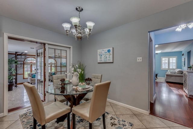 dining area with light hardwood / wood-style flooring and an inviting chandelier