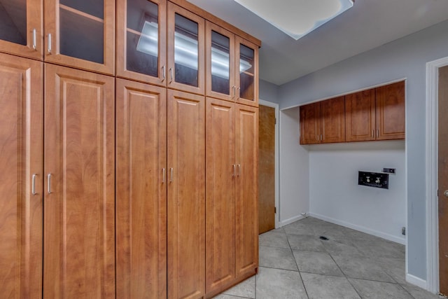 laundry room with washer hookup, cabinets, and light tile patterned floors