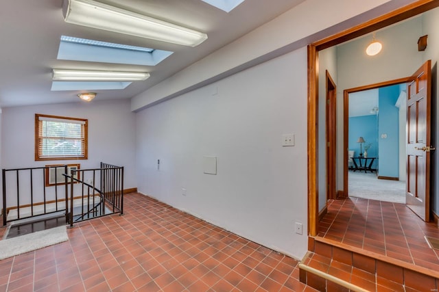 spare room featuring lofted ceiling with skylight