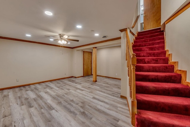 basement with ceiling fan, ornamental molding, and light hardwood / wood-style flooring