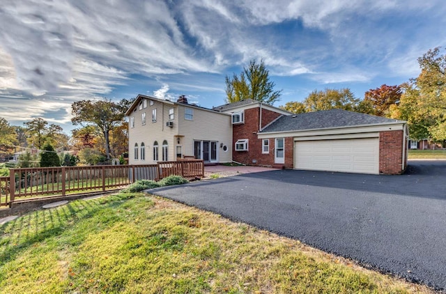 view of front of home with a garage, a front yard, and a deck