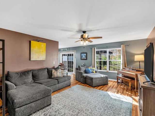 living room with a ceiling fan and wood finished floors