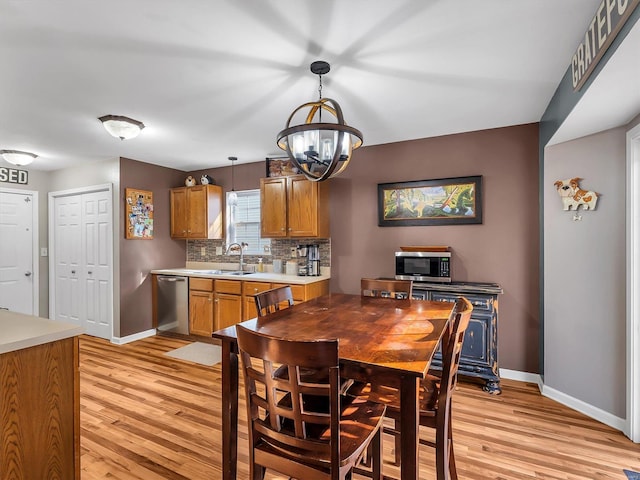 dining room with baseboards, a chandelier, and light wood-type flooring