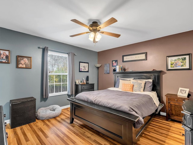 bedroom featuring baseboards, light wood-style floors, and ceiling fan