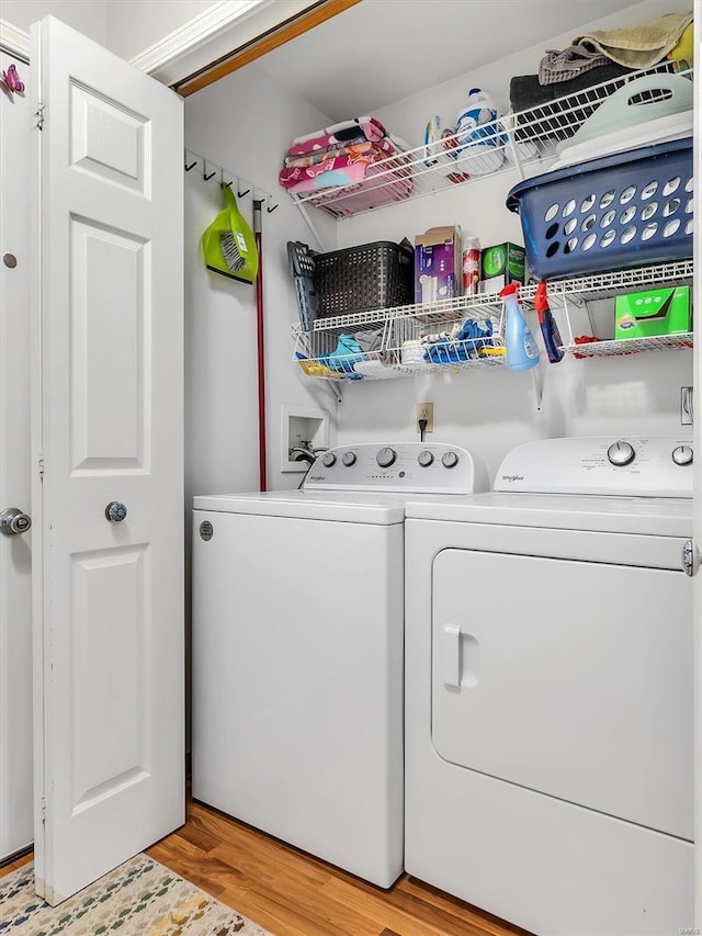 laundry room with laundry area, light wood finished floors, and washer and dryer