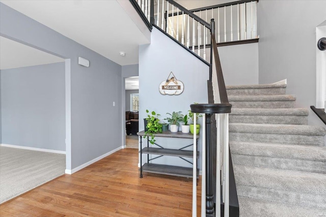 stairway featuring hardwood / wood-style floors and a towering ceiling