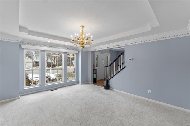 unfurnished room featuring an inviting chandelier, crown molding, a raised ceiling, and carpet