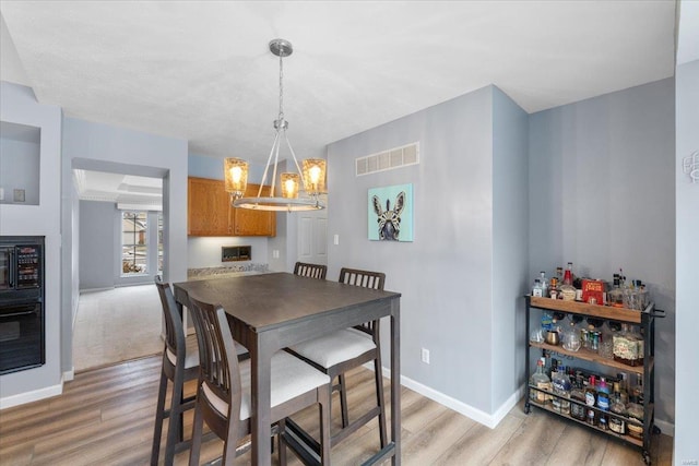 dining space featuring an inviting chandelier and light hardwood / wood-style floors