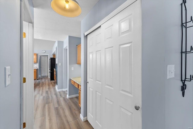 corridor with light hardwood / wood-style flooring