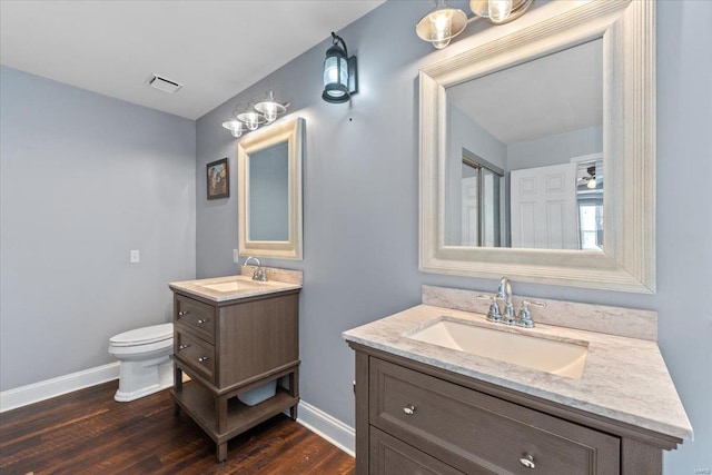 bathroom with vanity, toilet, and wood-type flooring