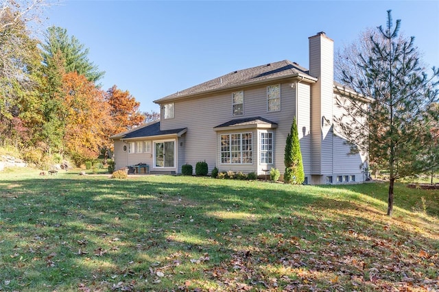 rear view of house featuring a lawn