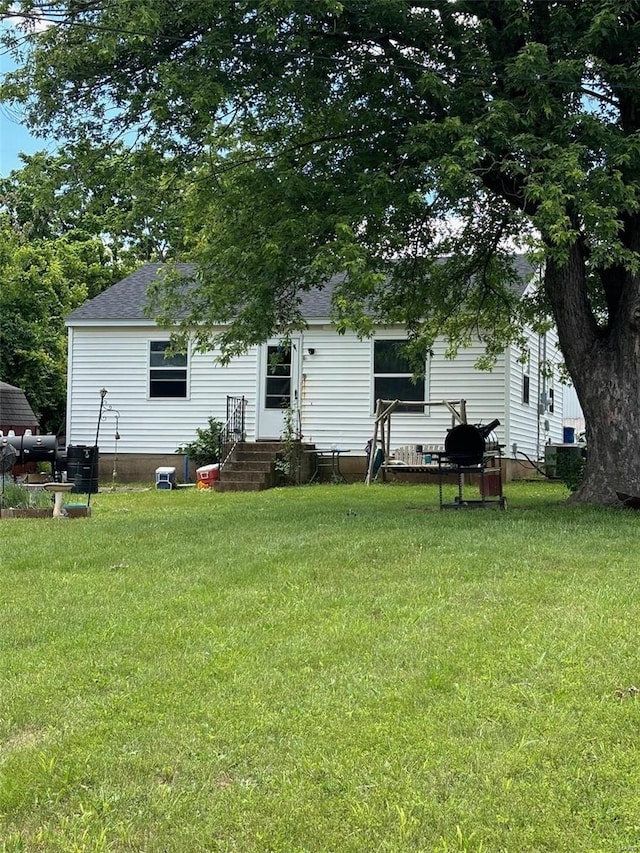 rear view of house featuring a lawn