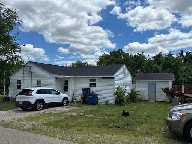 view of front facade featuring a storage shed, central AC, and a front lawn