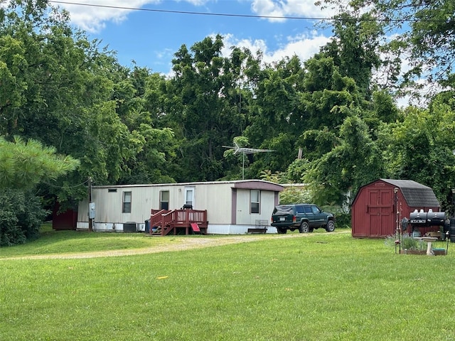 view of front of property featuring a front yard and a storage shed