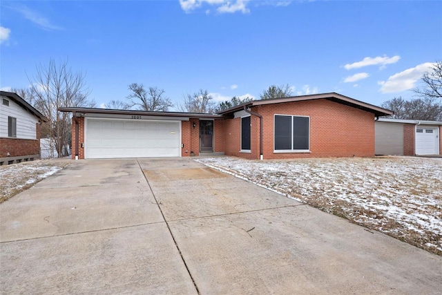 view of front of home featuring driveway, a garage, and brick siding