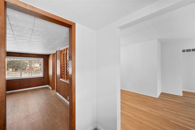 unfurnished room with wood finished floors, visible vents, and baseboards