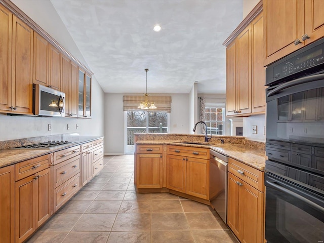 kitchen with light stone countertops, sink, stainless steel appliances, kitchen peninsula, and a chandelier