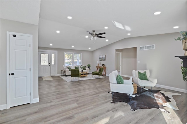 living area with light hardwood / wood-style floors, ceiling fan, and lofted ceiling