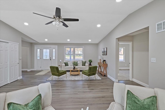 living room with a wealth of natural light, lofted ceiling, and hardwood / wood-style flooring