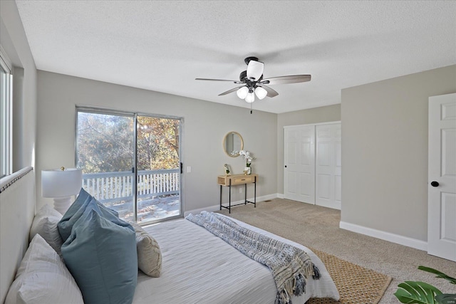 carpeted bedroom with access to outside, ceiling fan, a closet, and a textured ceiling