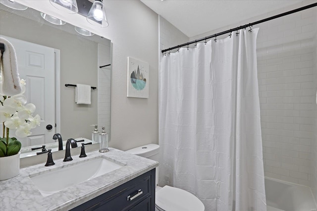 bathroom featuring vanity, a textured ceiling, and toilet