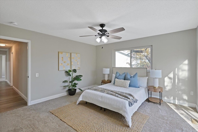 bedroom with carpet, ceiling fan, and a textured ceiling