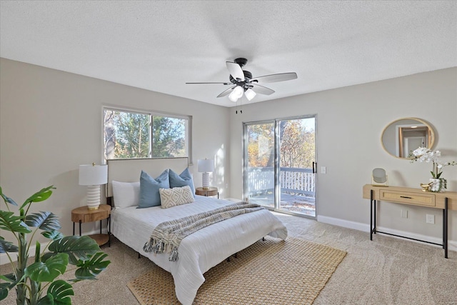 bedroom with a textured ceiling, access to exterior, ceiling fan, and multiple windows