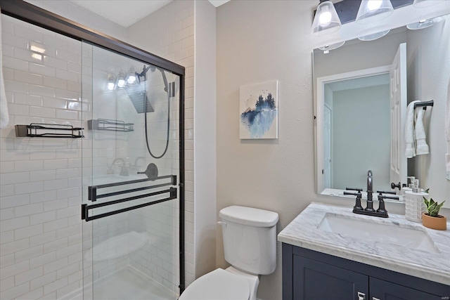 bathroom featuring vanity, toilet, and a shower with door