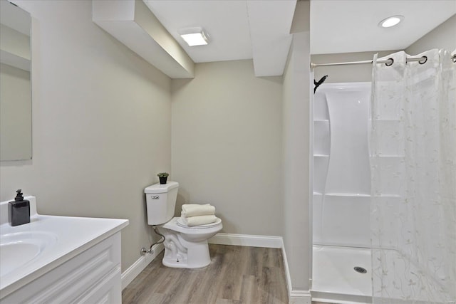 bathroom featuring hardwood / wood-style floors, vanity, toilet, and walk in shower