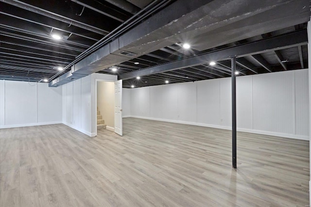 basement with light hardwood / wood-style flooring