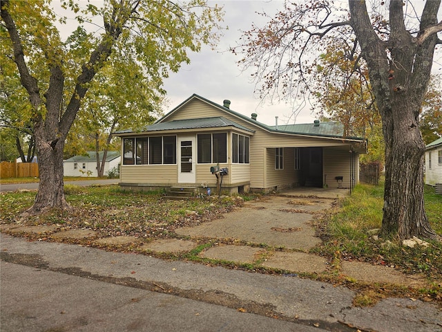 bungalow-style home with a sunroom and a carport