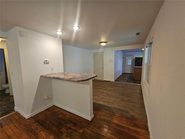 kitchen with kitchen peninsula and dark hardwood / wood-style floors