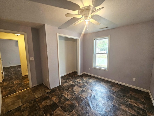 unfurnished bedroom with a closet, a textured ceiling, and ceiling fan