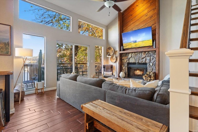 living room featuring a fireplace, ceiling fan, dark wood-type flooring, and high vaulted ceiling