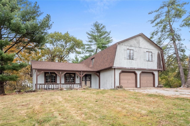 view of front of property with covered porch, a front yard, and a garage